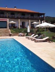 a villa with a swimming pool in front of a house at Quinta Da Pereira E Enricas Agro-Turismo in Vila Flor