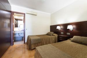 Een bed of bedden in een kamer bij TC Apartamentos Rocamar
