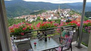 una mesa y sillas en un balcón con flores en Am Keschtewaeldele ****, en Forbach