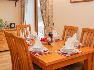 a wooden table with chairs and a table with wine glasses at Southdown in Much Wenlock