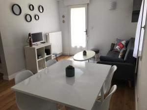 a white table and chairs in a living room at Gîte la Briantaise in Saint Malo