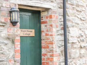 uma porta verde com um letreiro que lê a casa de banho em Wash House Cottage em Much Wenlock