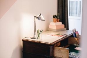 a desk with a lamp on top of it at La Maison d'Ambronay in Ambronay