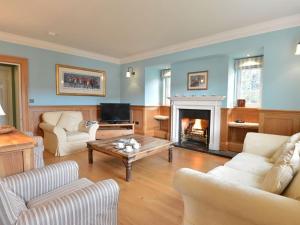 a living room with a fireplace and a table at Dinas Noddfa in Beddgelert
