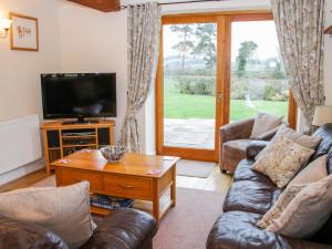 a living room with a couch and a tv at Southdown in Much Wenlock