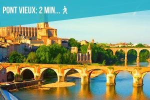 a bridge over a river in a city at Au Fil de L eau in Albi
