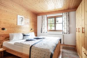 ein Schlafzimmer mit einem Bett und einer Holzwand in der Unterkunft Saxerhof in Schmirn
