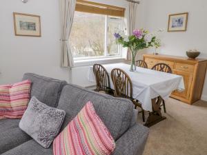 a living room with a couch and a table with a vase of flowers at The Dene in Betws-y-coed