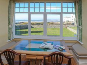 a table with two books on top of it with a window at Dunes - Rhosneigr in Rhosneigr