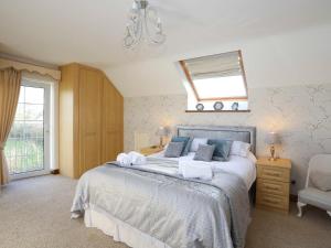 Un dormitorio con una cama con espejo y una ventana. en Dwyros, en Pwllheli