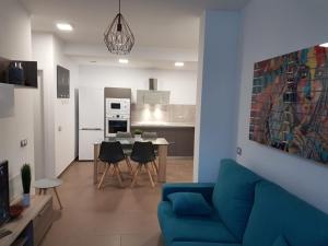 a living room with a blue couch and a kitchen at POZO STYLE in Pozo Izquierdo