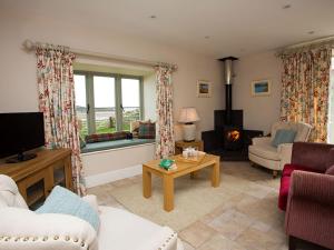 a living room with a couch and a tv at Estuary Cottage in Penrhos-Lligwy
