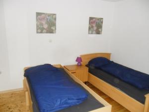 two beds with blue sheets in a room at Manfred Aepkers in Borgentreich