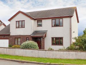 a white house with black windows at Fron in Menai Bridge