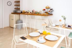 a table with white chairs and a white table with plates at Hotel Noualt in Ferreries