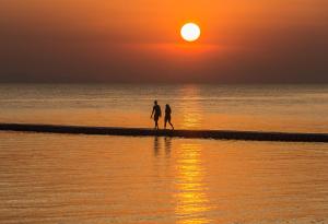 two people walking on the beach at sunset at Cocohut Beach Resort Koh Phangan in Haad Rin