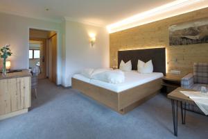 a bedroom with a large bed and a bathroom at Hotel Bergland in Pertisau