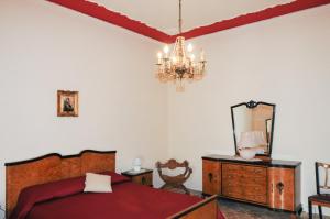 a bedroom with a bed and a mirror and a chandelier at CASA CALISI in Terrasini