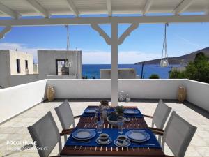 una mesa y sillas en un patio con vistas al océano en Estella’s House en Livadia