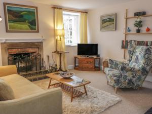a living room with a fireplace and a tv at The Cottage, Polwarth Crofts in Duns