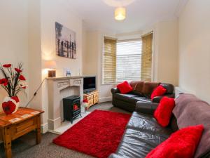 a living room with a leather couch and a fireplace at 18 Howard Street in Scarborough