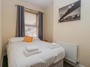 a bedroom with a bed with towels on it at 18 Howard Street in Scarborough