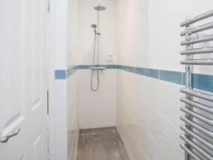 a bathroom with a shower with a glass door at Glan Dwr Bach in Llandegfan +11 photos
