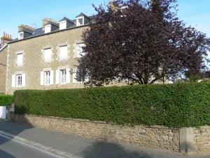 een bakstenen gebouw met een boom ervoor bij Le Petit Bleu - Appt à 5m de la plage in Dinard