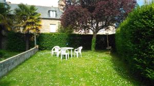 twee stoelen en een tafel in de tuin bij Le Petit Bleu - Appt à 5m de la plage in Dinard +3 foto's