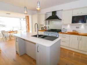 a white kitchen with a sink and a stove at Shady Bowers in Carnforth