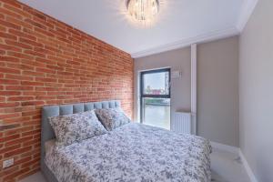 een slaapkamer met een bakstenen muur en een bed bij MIRA APARTMENTS in Gdańsk