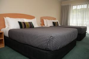 a hotel room with two beds and a window at Greenlane Manor Motel in Auckland