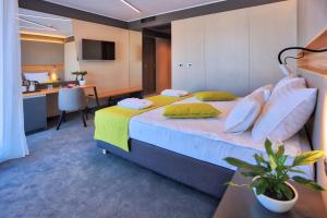 a bedroom with a large bed and a kitchen at Hotel Olea in Novalja