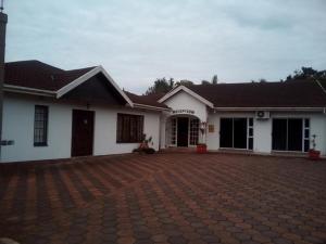 a white house with a brick driveway in front of it at Isibaya Guest Lodge in Richards Bay