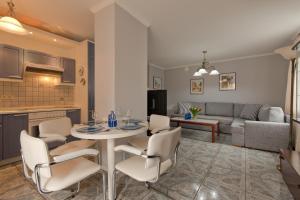 uma cozinha e uma sala de estar com mesa e cadeiras em Imperial Apartments - Nadmorski em Sopot