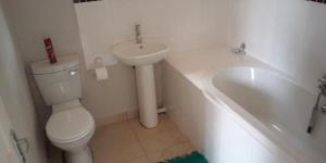 a bathroom with a toilet and a sink and a tub at Isibaya Guest Lodge in Richards Bay +10 photos