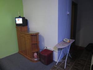 a room with a tv on a dresser and a table at Happy Owl in Ipoh
