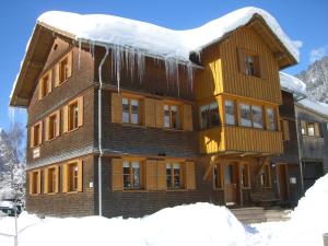 ein schneebedecktes Gebäude mit Eiszapfen drauf in der Unterkunft Urlaub bei Moses in Schoppernau