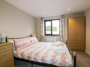 a bedroom with a bed and a dresser and a window at Little May in Newquay