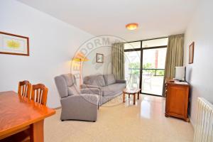 ein Wohnzimmer mit einem Sofa, Stühlen und einem Tisch in der Unterkunft Apartamentos Paraíso Centro - BenidormParaíso in Benidorm