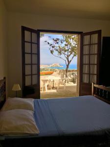 a bedroom with a bed and a window with a view at Relais International de la Jeunesse in Calvi