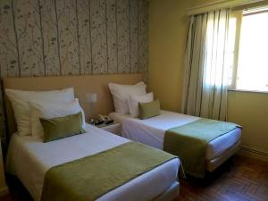 ein Hotelzimmer mit 2 Betten und einem Fenster in der Unterkunft Adelaide Hotel in Geres