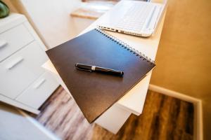 a pen on a notebook on a desk with a laptop at Riva Palace - design rooms in Zadar