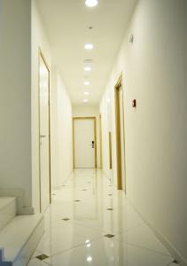 an empty hallway with white walls and a door at Hai Hotel in Larnaca