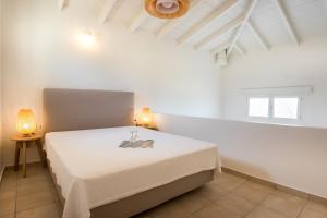 een witte slaapkamer met een bed in een kamer bij Neapoli Villas in Neapolis