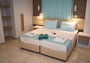 a bedroom with a bed with towels and shoes on it at Hai Hotel in Larnaca