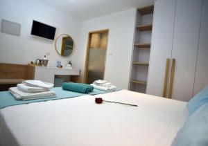 a bedroom with a white bed with towels and a mirror at Hai Hotel in Larnaca
