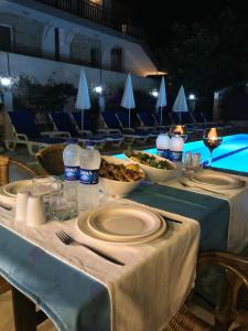 a table with plates of food and bottles of water at Minta Apart Hotel in Kemer