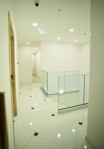 a white hallway with a glass wall in a building at Hai Hotel in Larnaca