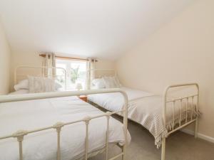 two beds in a room with a window at 2 Hillside Cottages in Ipswich